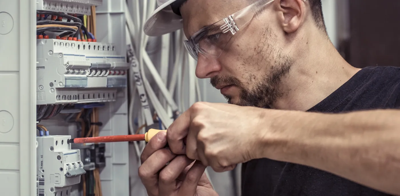 Électricien réglant un module domotique sur un tableau Hager dans le sud du 93
